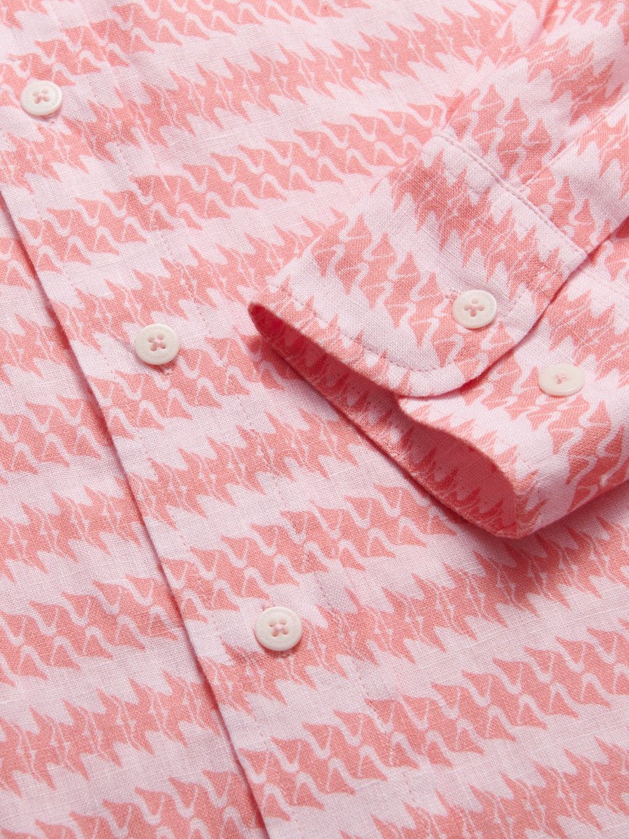 Close-up of Roseate Spoonbill Abaco men's Linen Shirt fabric, featuring pink and white bird print with white buttons. Old money shirts made from 100% linen.