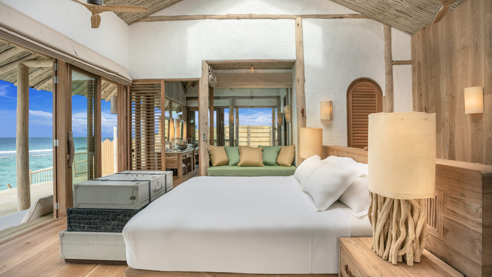Luxury bedroom at Soneva Fushi with ocean view, bed, and seating area.