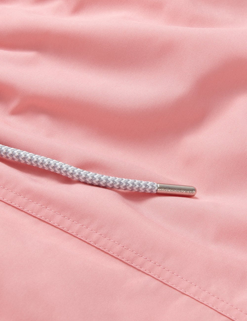 Men's Pastel Pink Staniel Swim Shorts. Plain pink swim shorts close-up image showcasing stitching and drawstring.