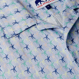 Close-up view of Star Dancer Arawak mens Linen Shirt featuring a pastel pink, limoncello, cay green, and deep blue sea star motif on a soothing ocean blue background.