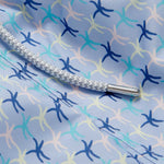 Close-up of the sea star pattern on the Men's Star Dancer Staniel Swim Shorts, showcasing pastel pink, zesty limoncello, fresh cay green, and deep ocean blue hues with a braided drawstring.