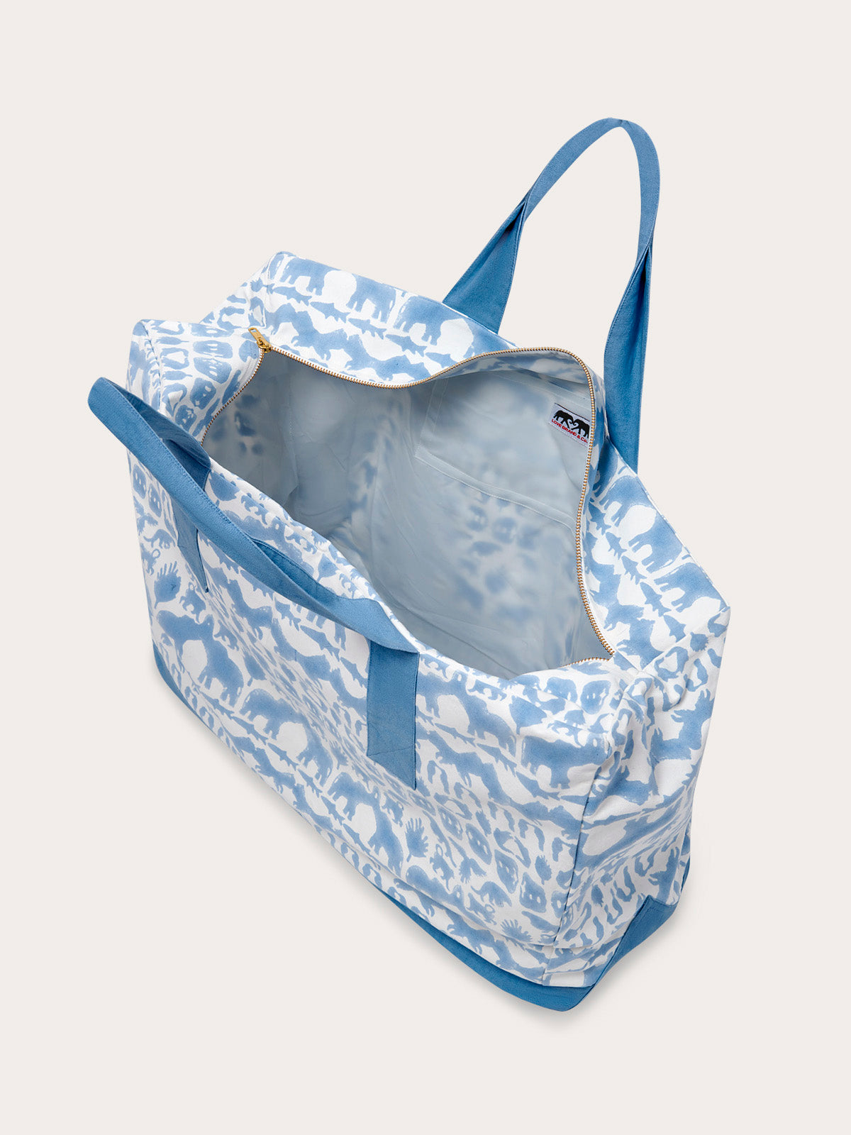 Sky blue canvas tote bag featuring Coexist animal print, open view showing interior pockets, and blue straps.