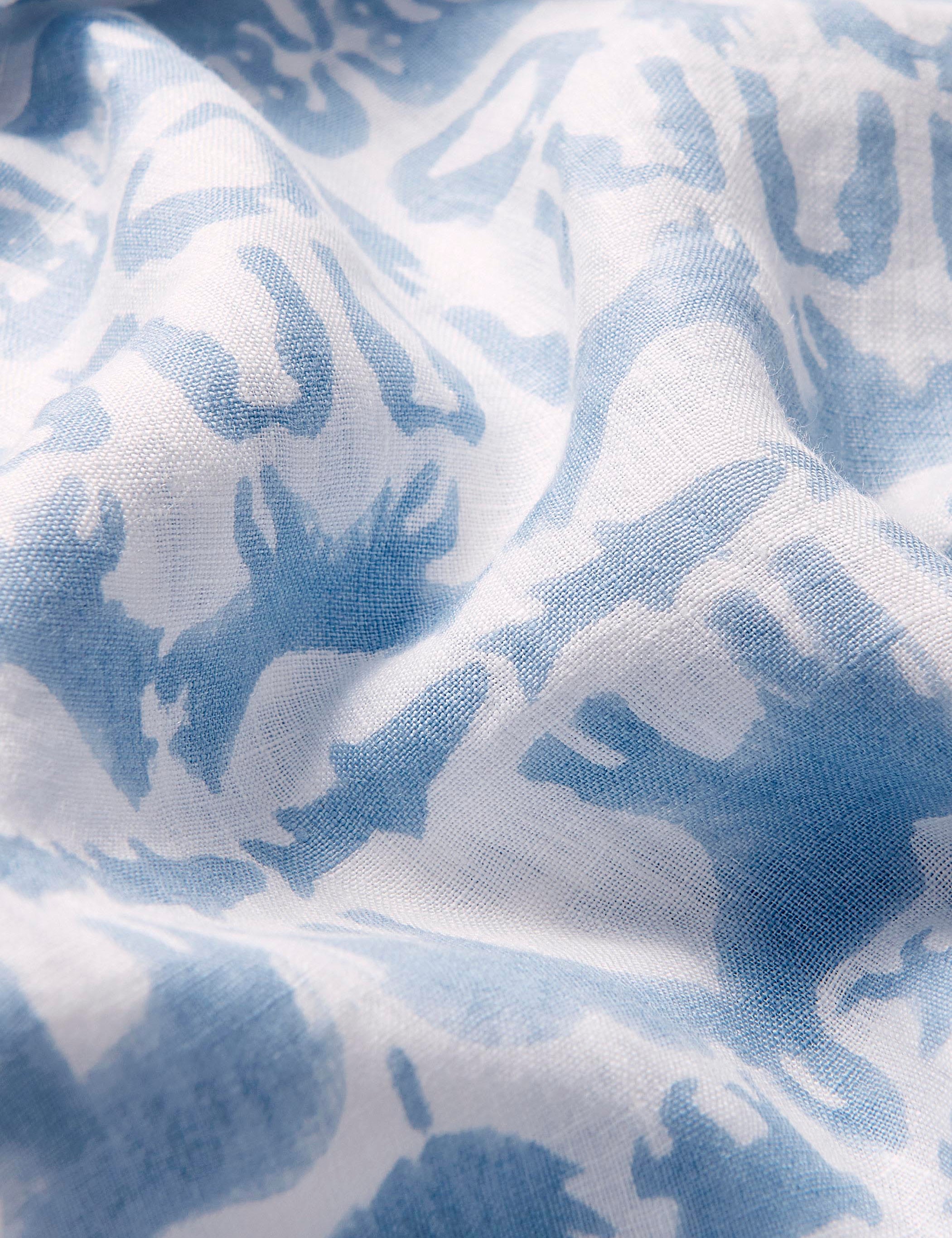 Close-up view of sky blue animal print on the Unisex Eleuthera linen Trousers made from 100% premium Belgian linen.