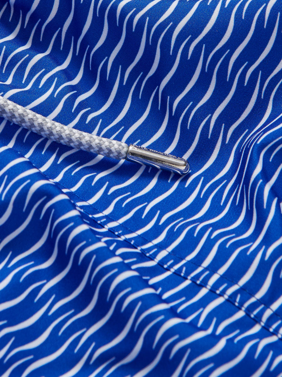 Close-up image of Men's Waves Staniel Swim Shorts in blue with white wave pattern and white drawstring detail.