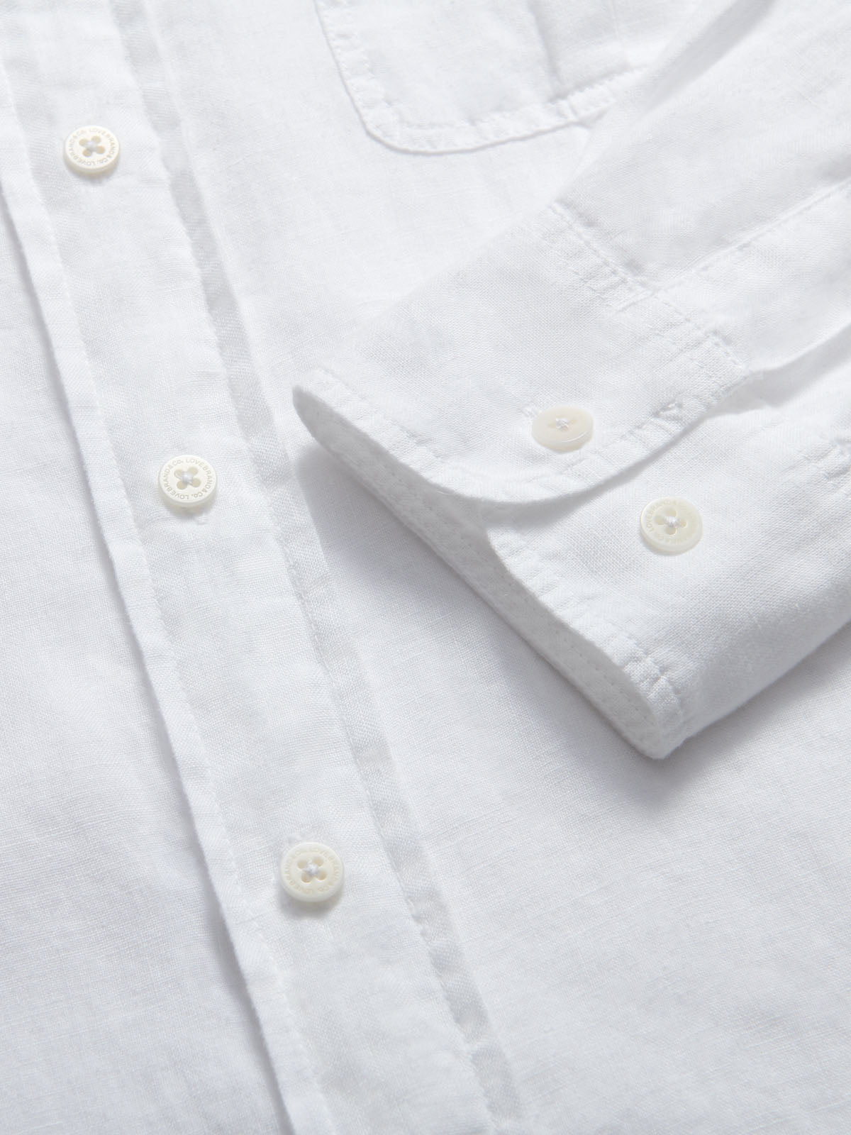 Men's White Andros Hemp Shirt with pleated double chest pockets and signature corozo nut buttons, made from 100% organic hemp for strength and comfort.