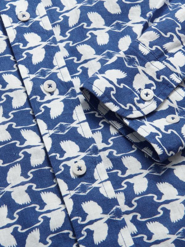 Close-up of Men's White Heron Abaco Linen Shirt featuring a deep blue background with white heron prints. Old money shirt designed for The Boca Raton by LOVE BRAND & Co.