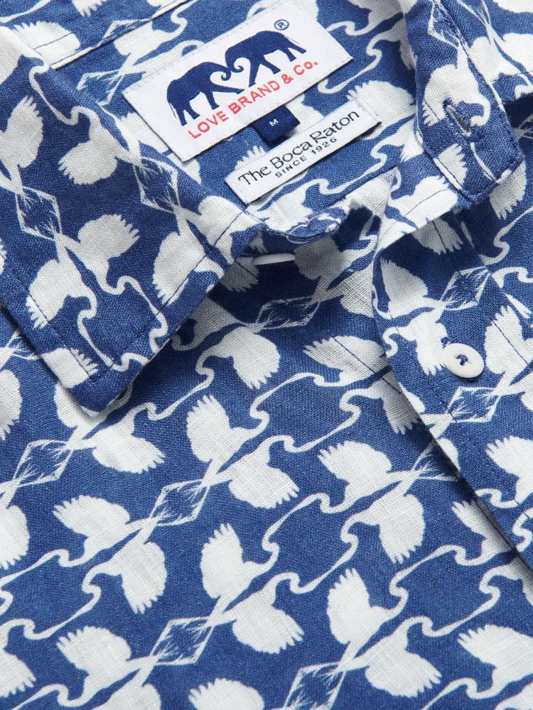 Close-up of the Men's White Heron Manjack Linen Shirt, showcasing its blue and white pattern featuring the Great White Heron. Men's linen shirt crafted from 100% linen with a button-up short-sleeved design.