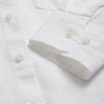 Detailed view of the cuffs of Womens White Inagua Linen Shirt. Long-sleeved button-up plain linen shirt with front pocket. Cuffs showing sustainable corozo nut button fastening.