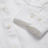 Detailed view of the cuffs of Womens White Inagua Linen Shirt. Long-sleeved button-up plain linen shirt with front pocket. Cuffs showing sustainable corozo nut button fastening.