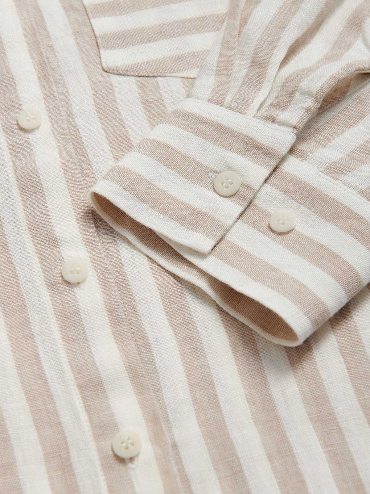 Close-up view of the cuff of Womens Coconut Stripe Inagua Linen Shirt. Long-sleeved button-up 100% linen shirt with front pocket. Brown and white striped patterned all over.