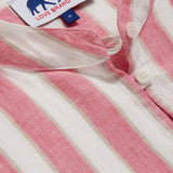 Detailed view of Womens Strawberries & Cream Jumento Linen Poncho. Half-button up, short-sleeved linen poncho in a white and pink striped pattern. Picture showcases white corozo nut buttons and love brand label.