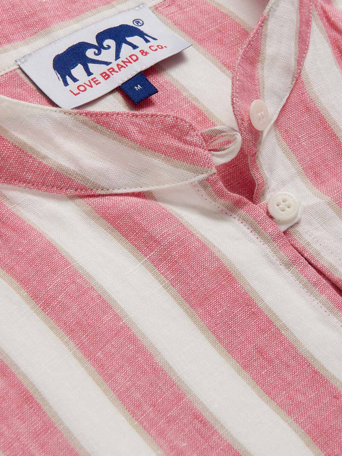 Detailed view of Womens Strawberries & Cream Jumento Linen Poncho. Half-button up, short-sleeved linen poncho in a white and pink striped pattern. Picture showcases white corozo nut buttons and love brand label.