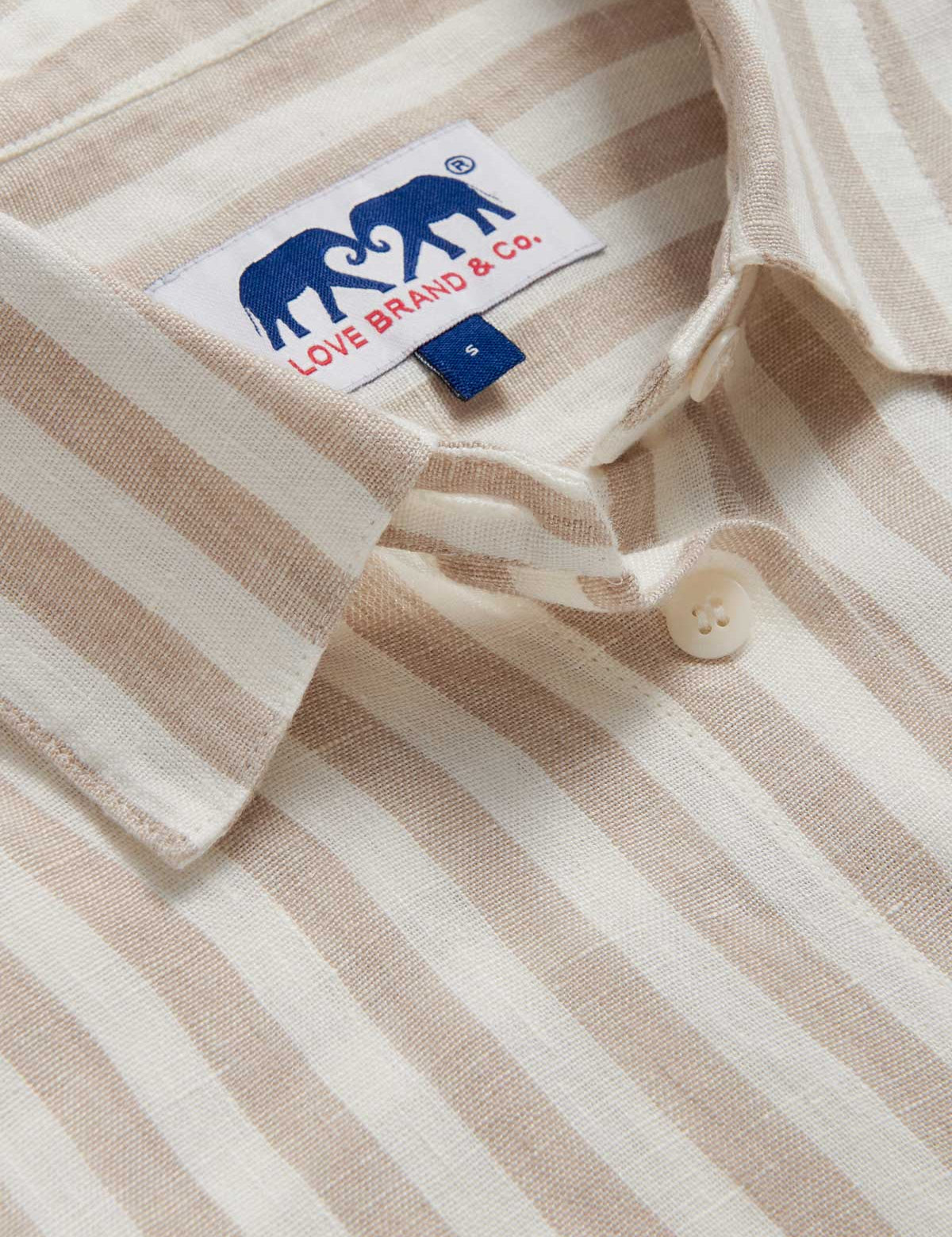 Close-up view of Womens Coconut Stripe Inagua Linen Shirt. Long-sleeved button-up 100% linen shirt with front pocket. Brown and white striped patterned all over.