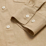 Beige midaxi linen shirt dress for women with long sleeves and a front pocket. Close-up view of cuff and linen fabric.