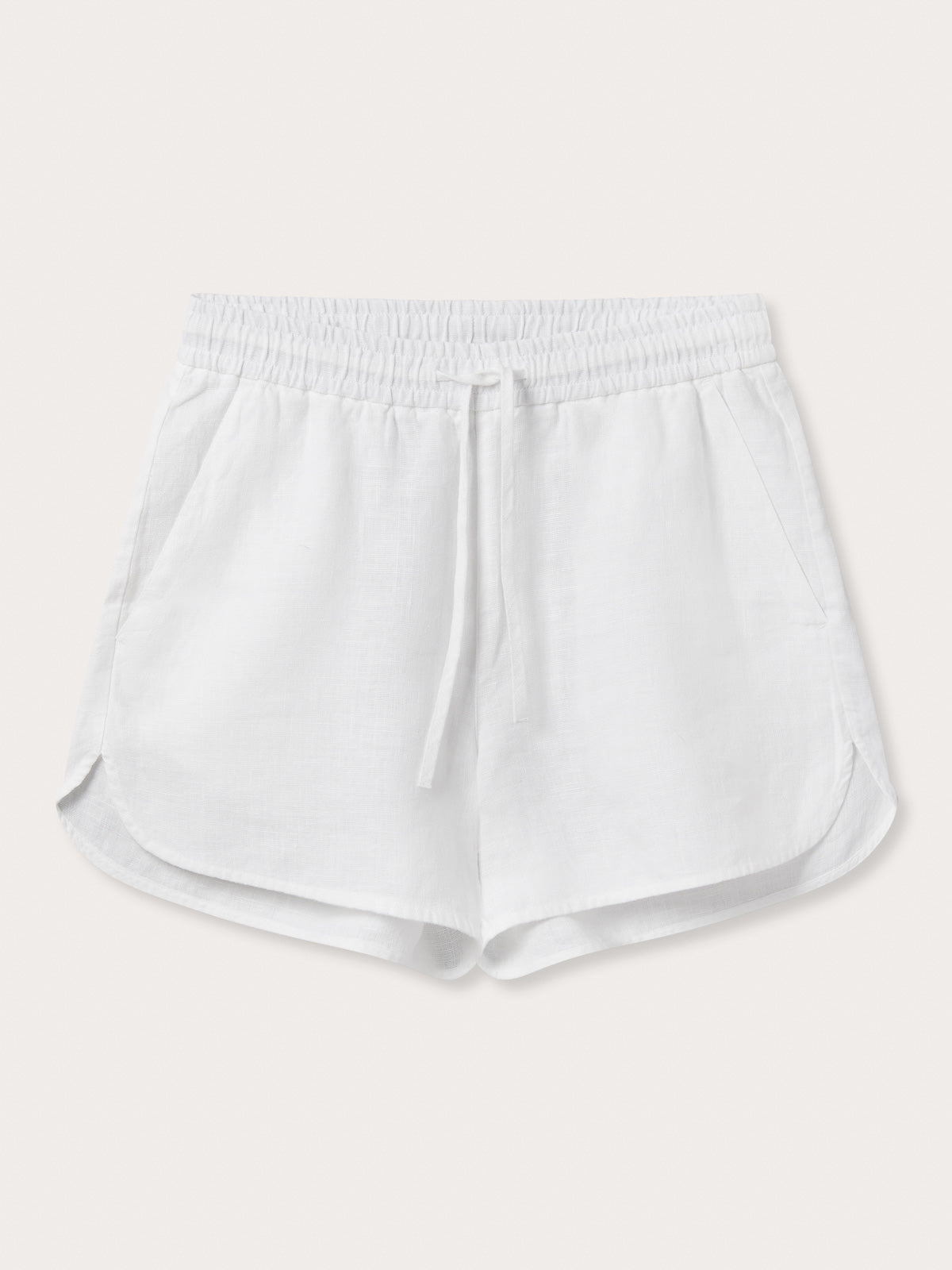 Front view of Womens White Musha Linen Shorts. 100% linen shorts in a relaxed fit with 2 front pockets. Featuring an elastic drawstring waist.