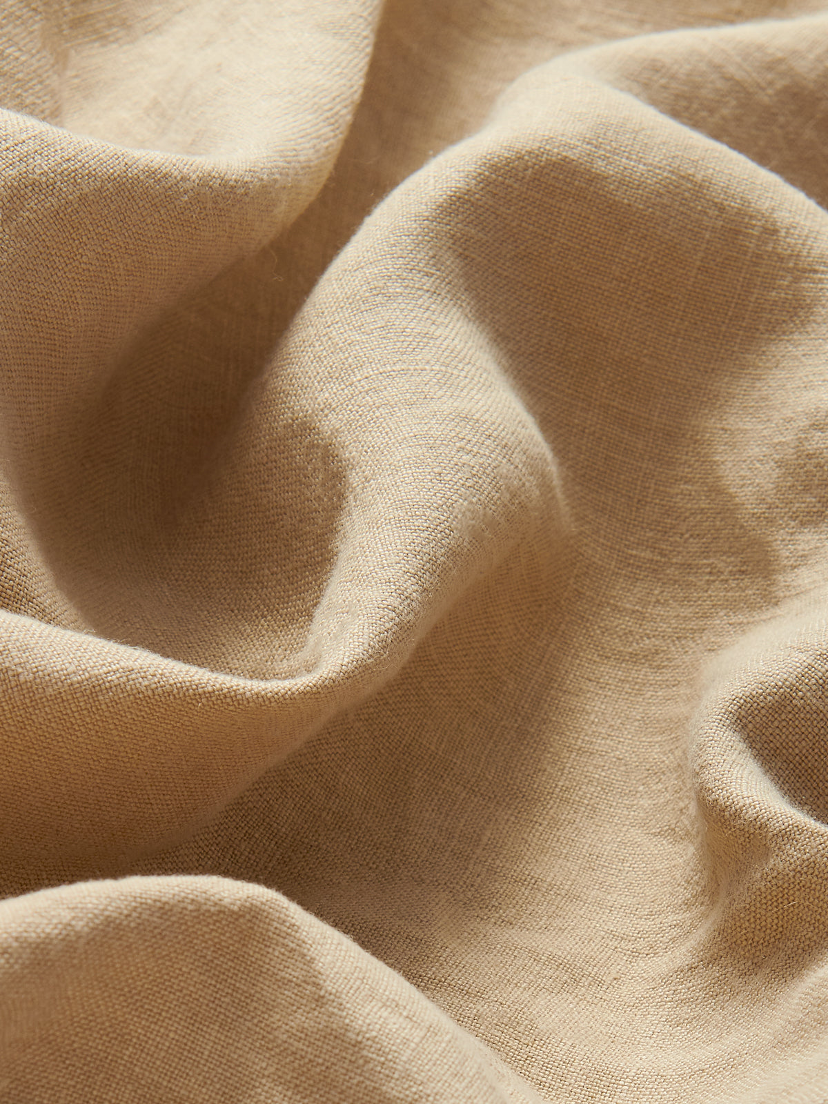 Close-up view of 100% line fabric of Womens Coconut Musha Linen Shorts. Beige linen shorts with 2 front pockets and drawstring waist in a relaxed fit. 