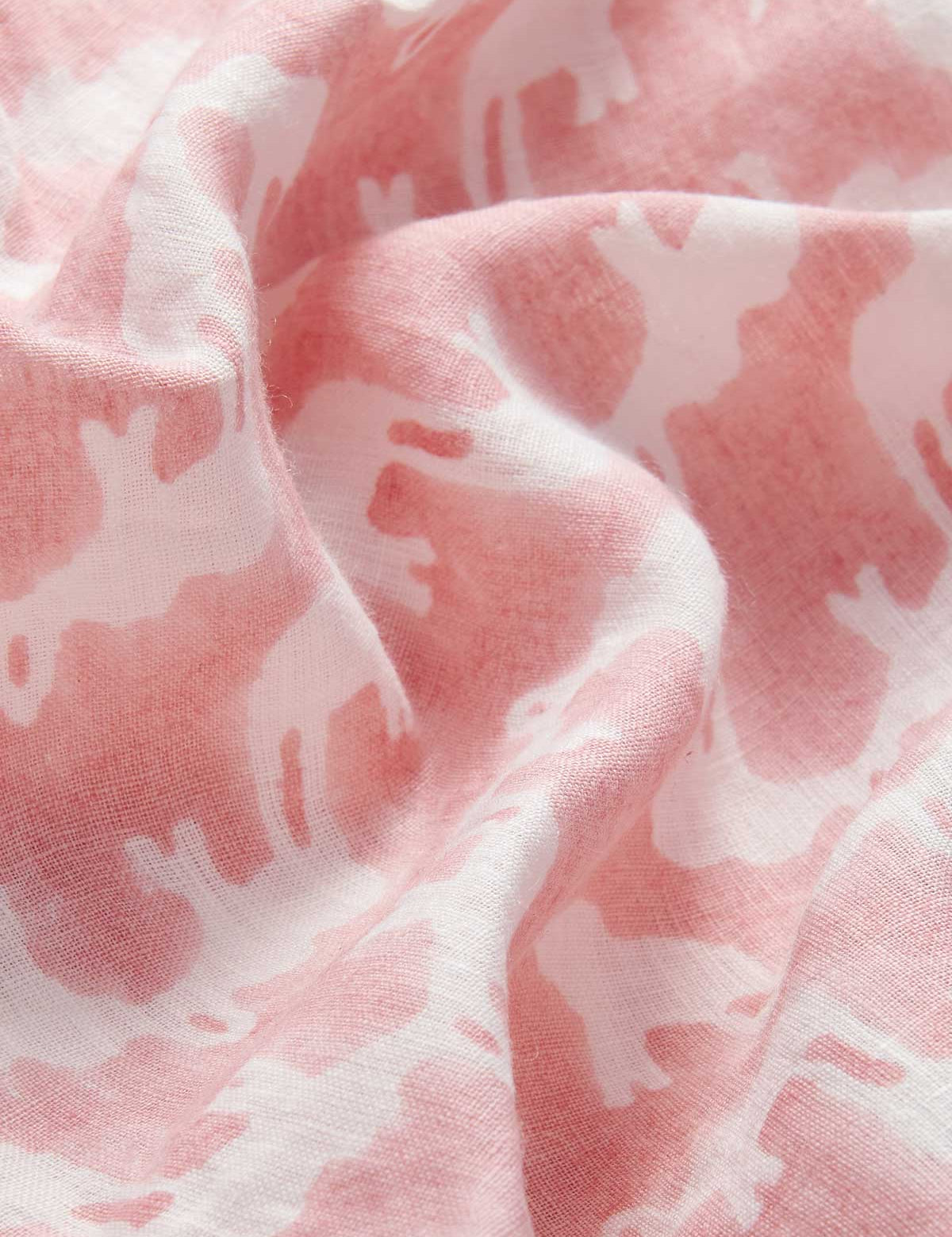 Deatiled view of Womens Elephant Palace Strawberry Musha Linen Shorts. Close-up of pink and white elephant print made from 100% linen hand block-printed by Indian artisans.