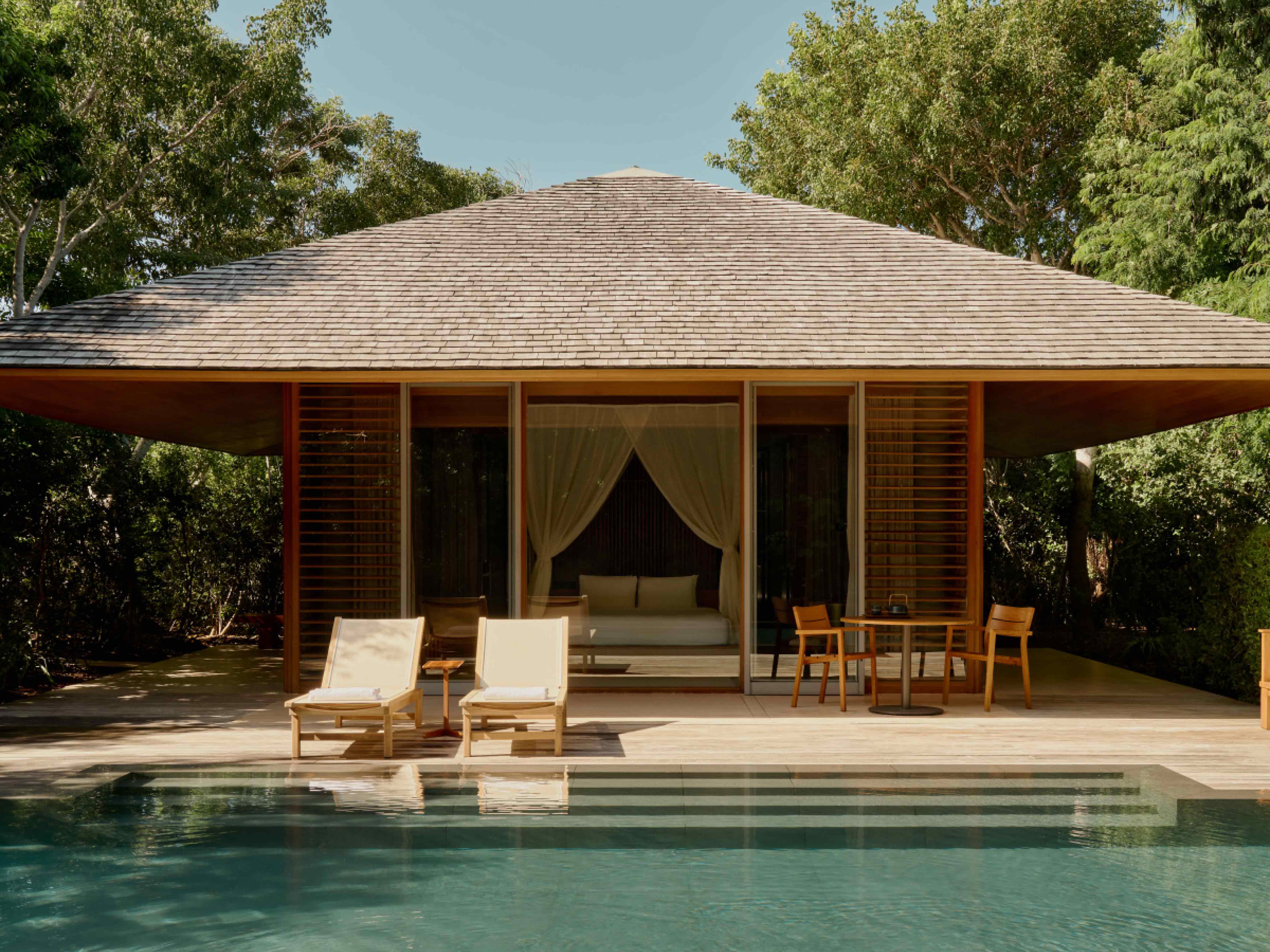 Modern gazebo house with a pool and outdoor furniture surrounded by trees
