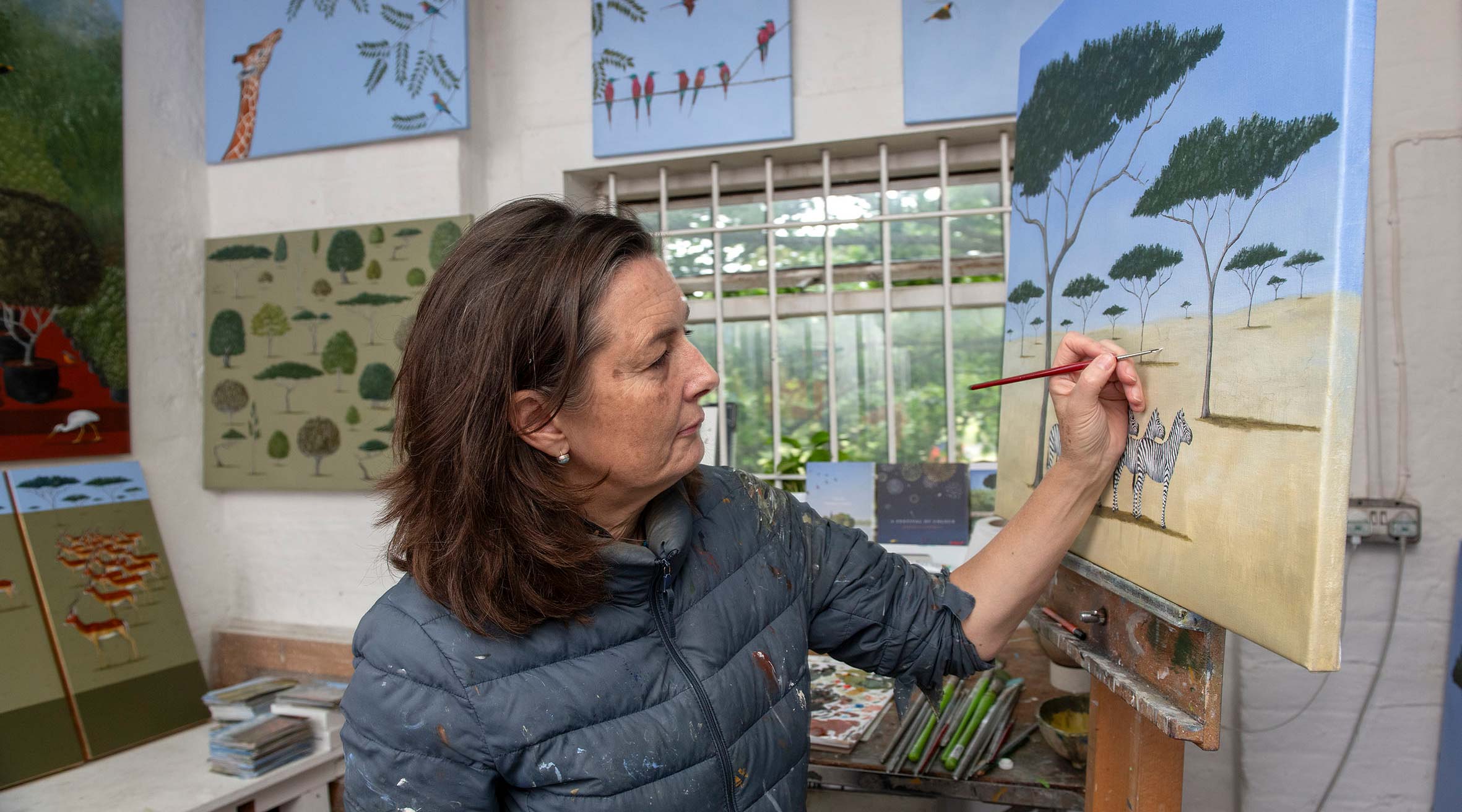 Artist Rebecca Campbell painting in her studio