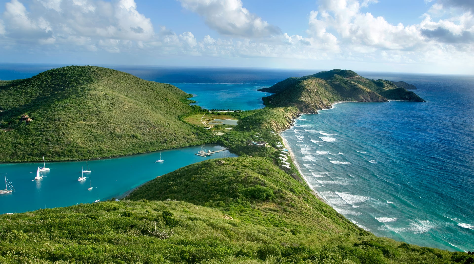 Scenic view of Biras Creek with green hills and clear blue waters.