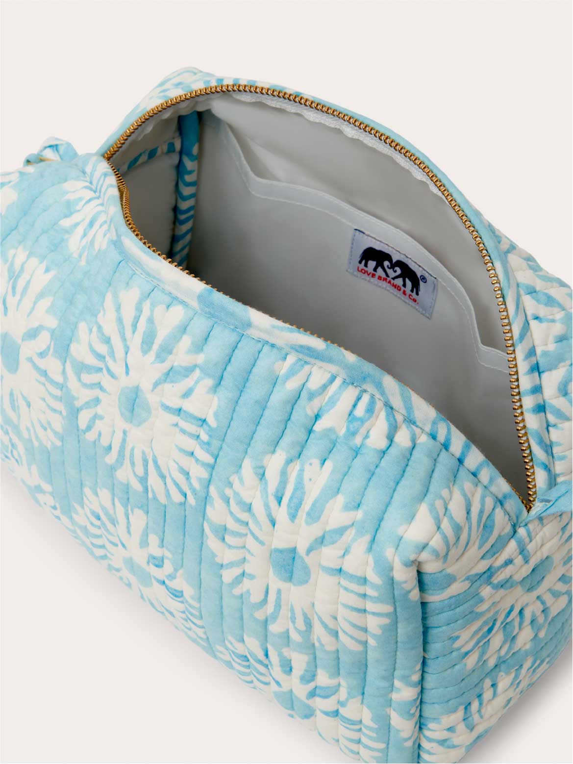 Blue coral-patterned bag with a visible brand logo inside on a white background