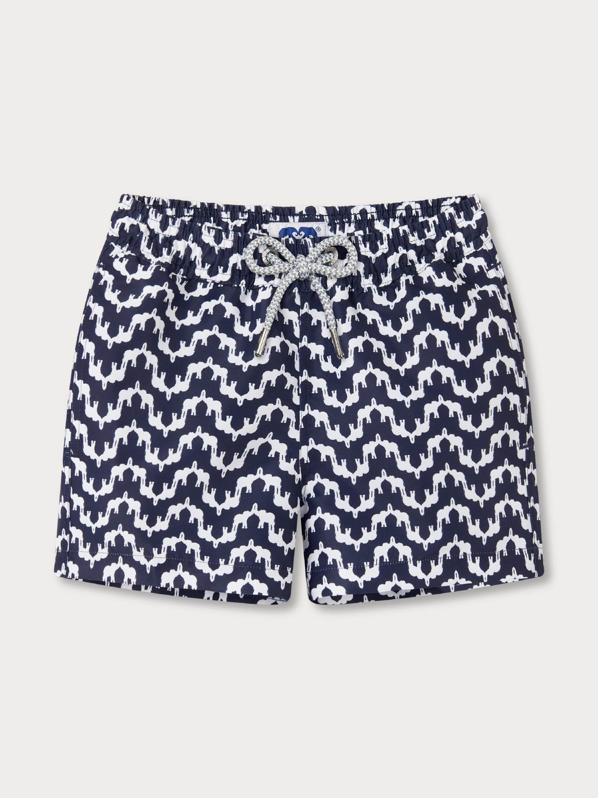Navy and white patterned swim shorts for kids on a light grey background
