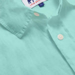 Close-up view of the Men's Cay Green Abaco Linen Shirt fabric, showcasing the vibrant green hue and fine texture of the 100% linen material.