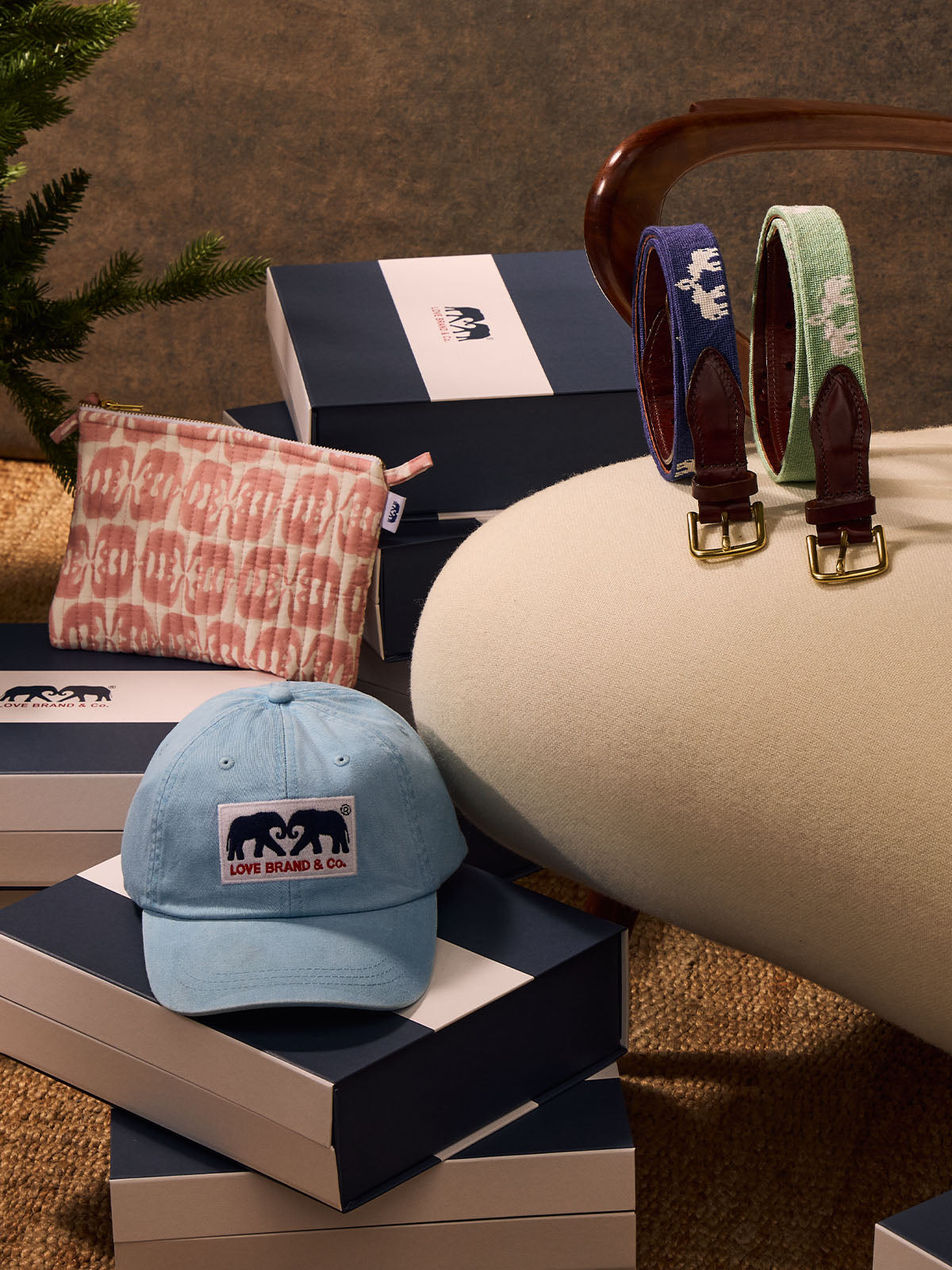 Blue cap, patterned bag and belts on a textured surface with a box in the background.