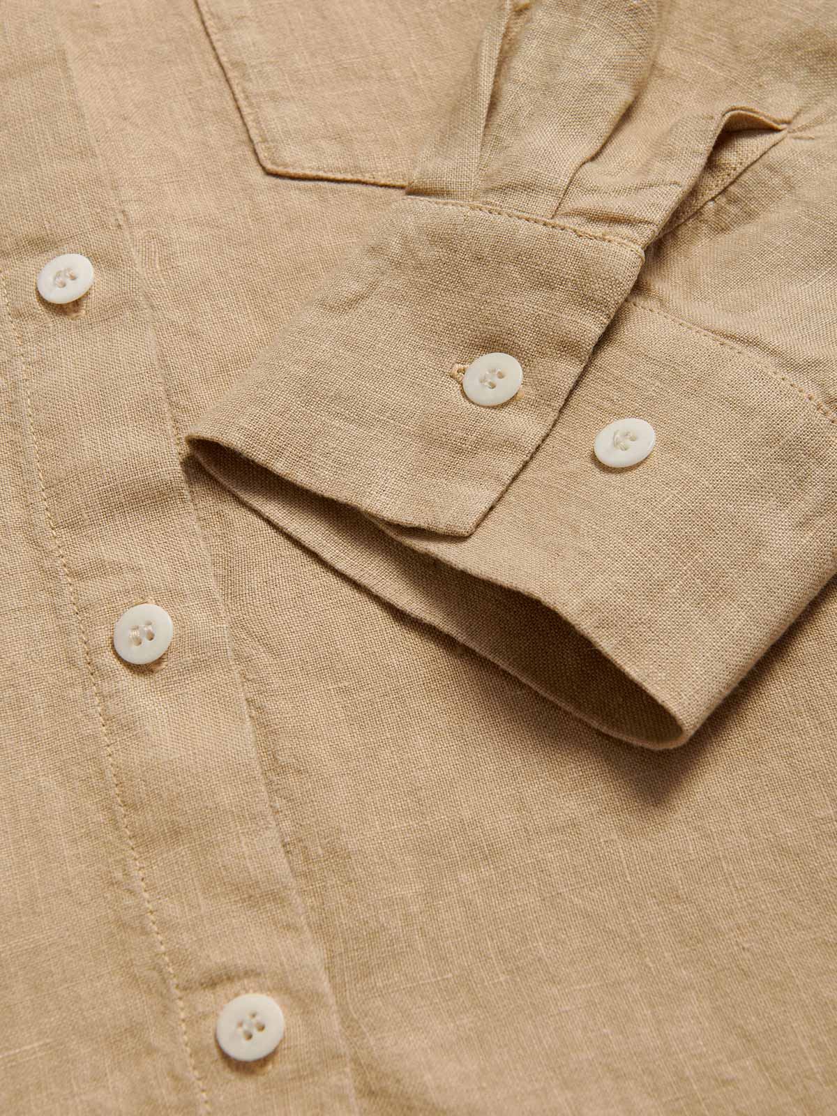 Close-up view of Womens Coconut Inagua Linen Shirt. Long-sleeved brown linen shirt with button-up design and front pocket. Crafted from 100% linen.