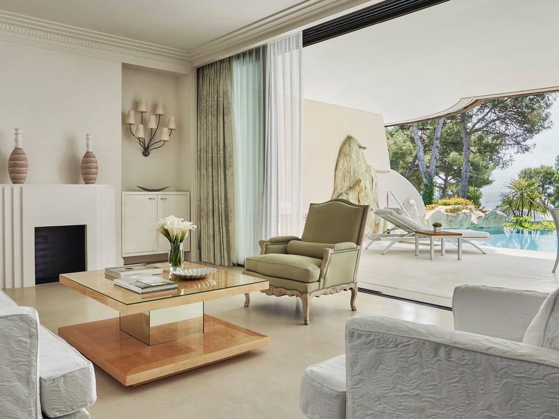 Luxurious living room with a view of a pool and garden.