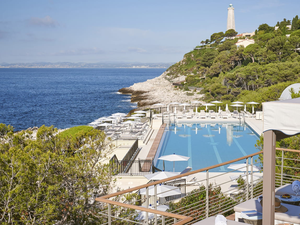 Luxury pool area with ocean view and lighthouse in the background at Four Seasons France