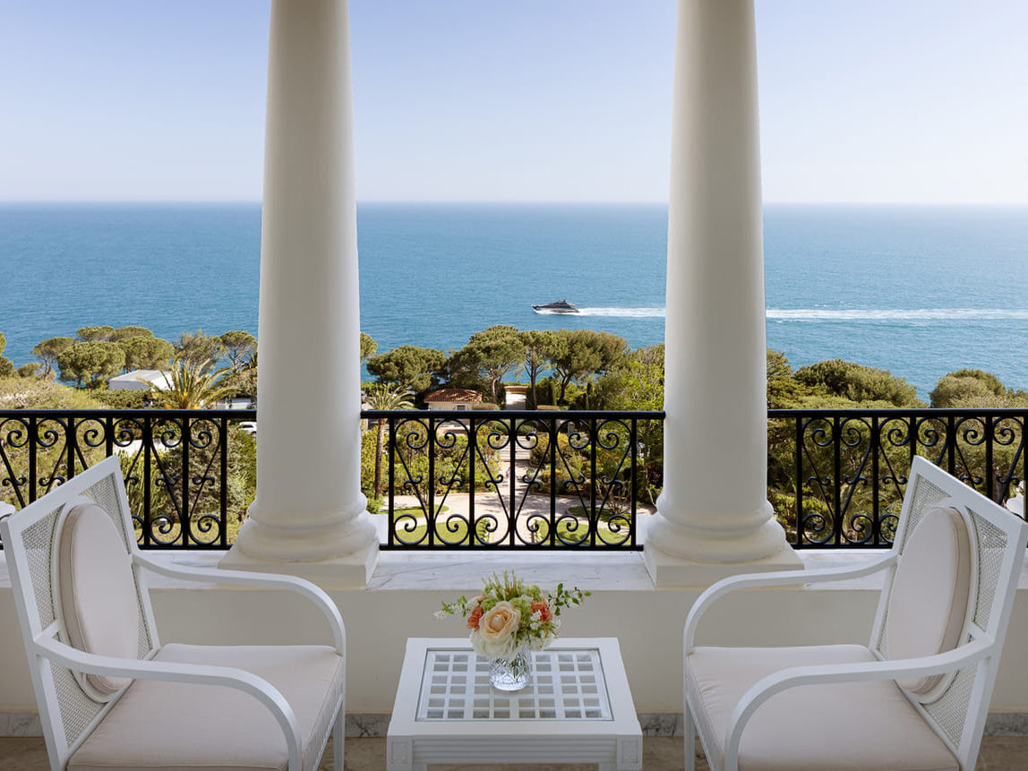 White chairs and table on a balcony at the Four Seasons France with ocean view
