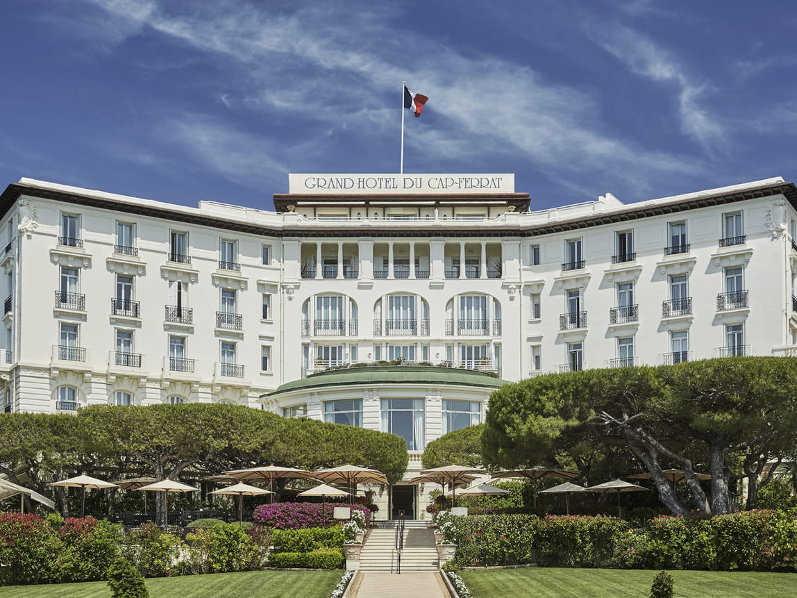 Grand Hotel du Cap-ferrat with a clear blue sky and greenery.