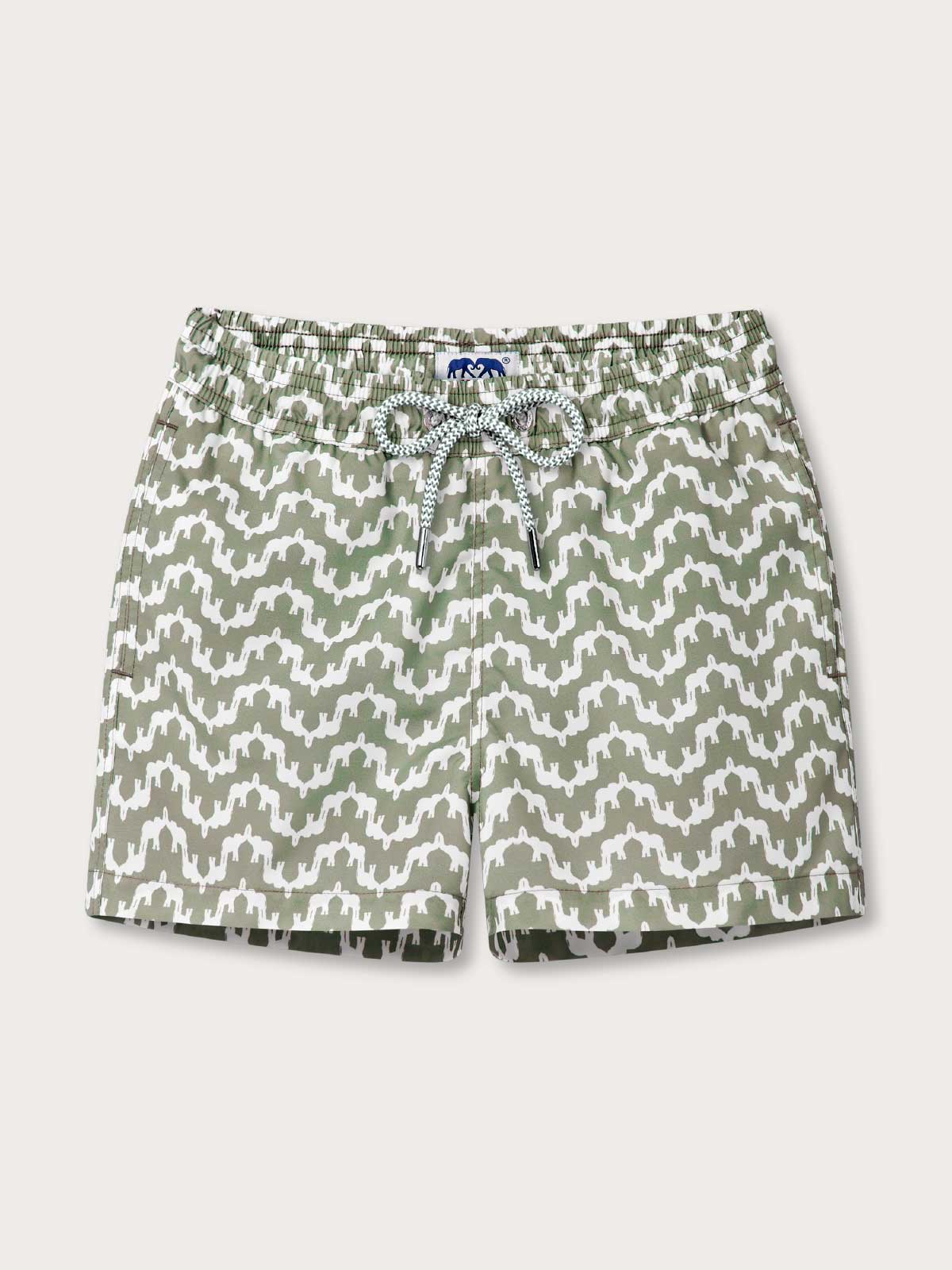 Green and white patterned swim shorts on a light grey background