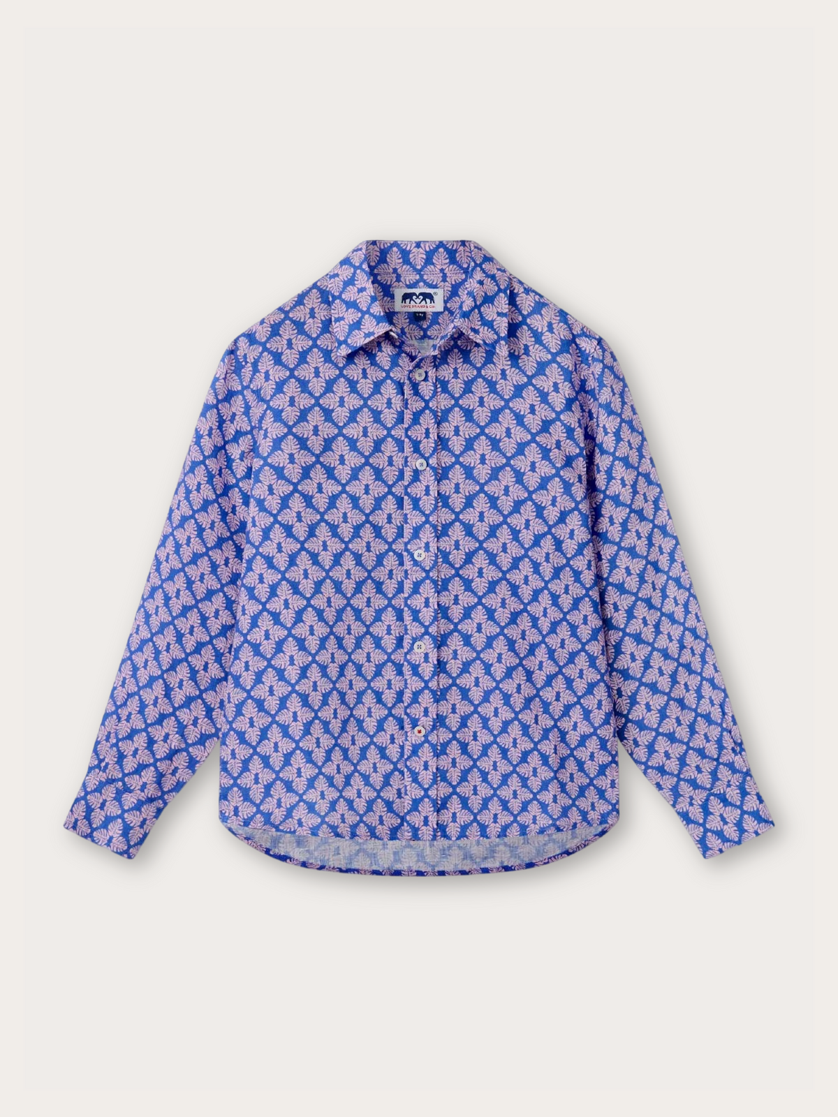 A long-sleeve button-up shirt with a repeating blue and pink geometric pattern, displayed flat against a light off-white background.