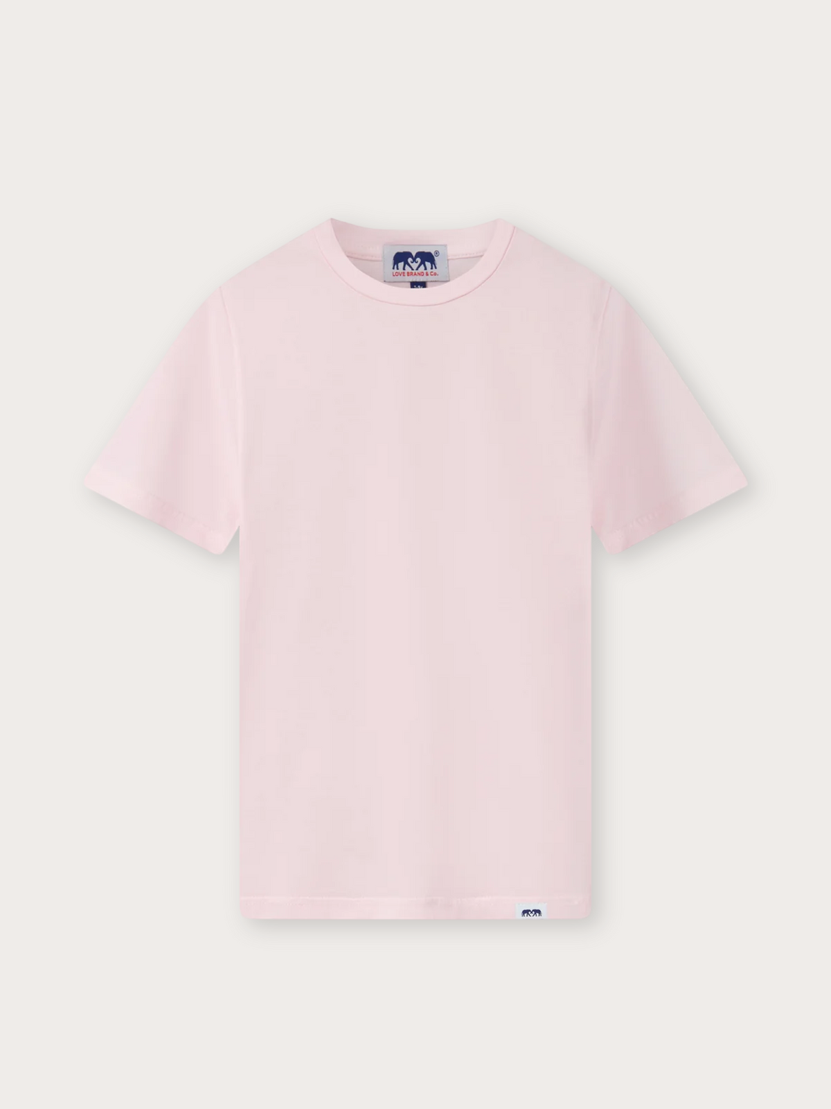 A light pink short-sleeve crewneck t-shirt with a small blue and white logo tag on the inside neck and a matching small tag on the bottom hem, displayed flat against a light off-white background.
