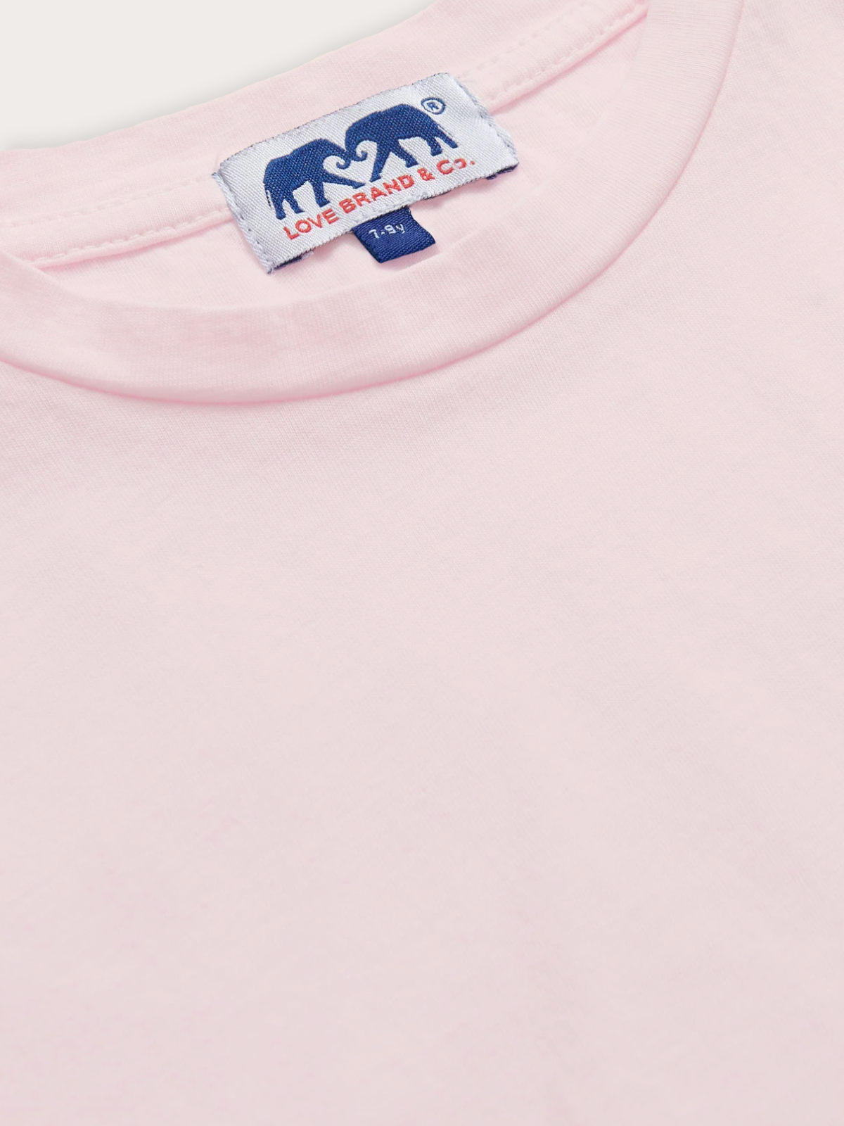 Detailed view of a light pink t-shirt for children.