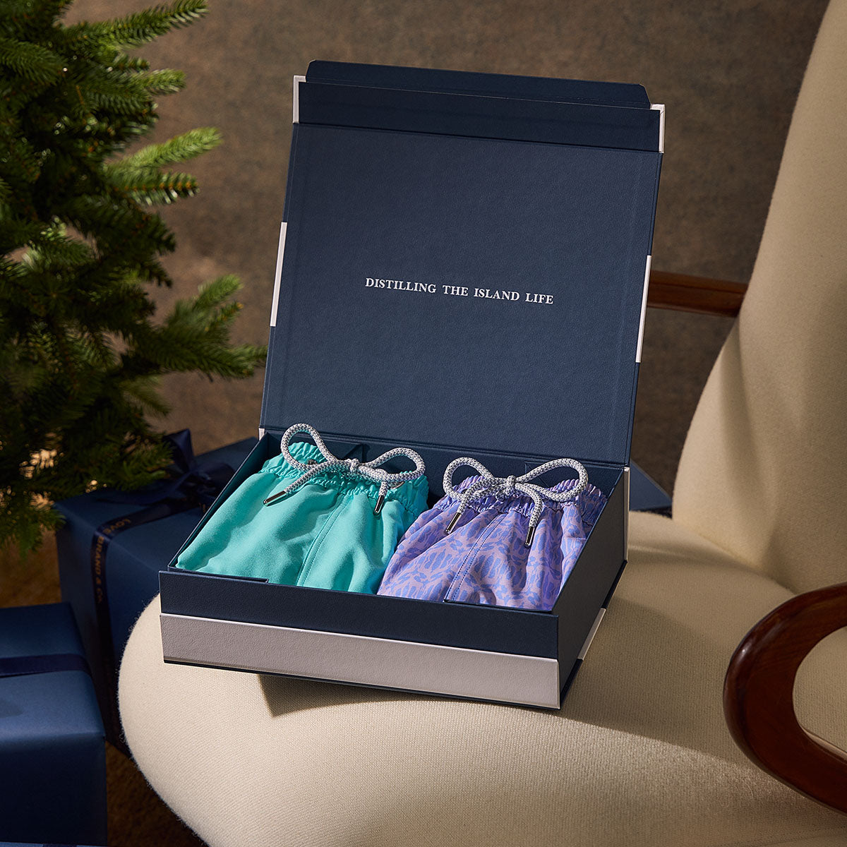 Open navy blue box with turquoise and purple swimming trunks inside.