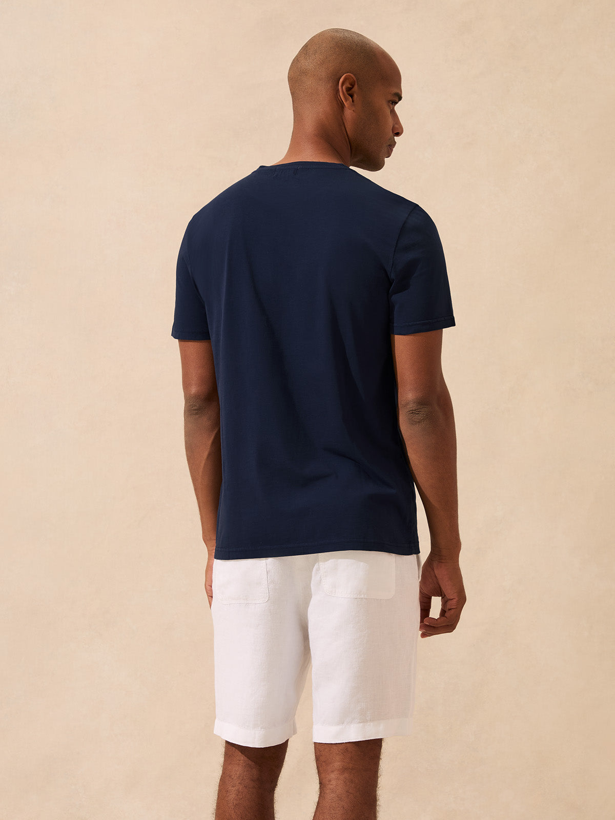 back view of a man wearing a navy cotton t-shirt