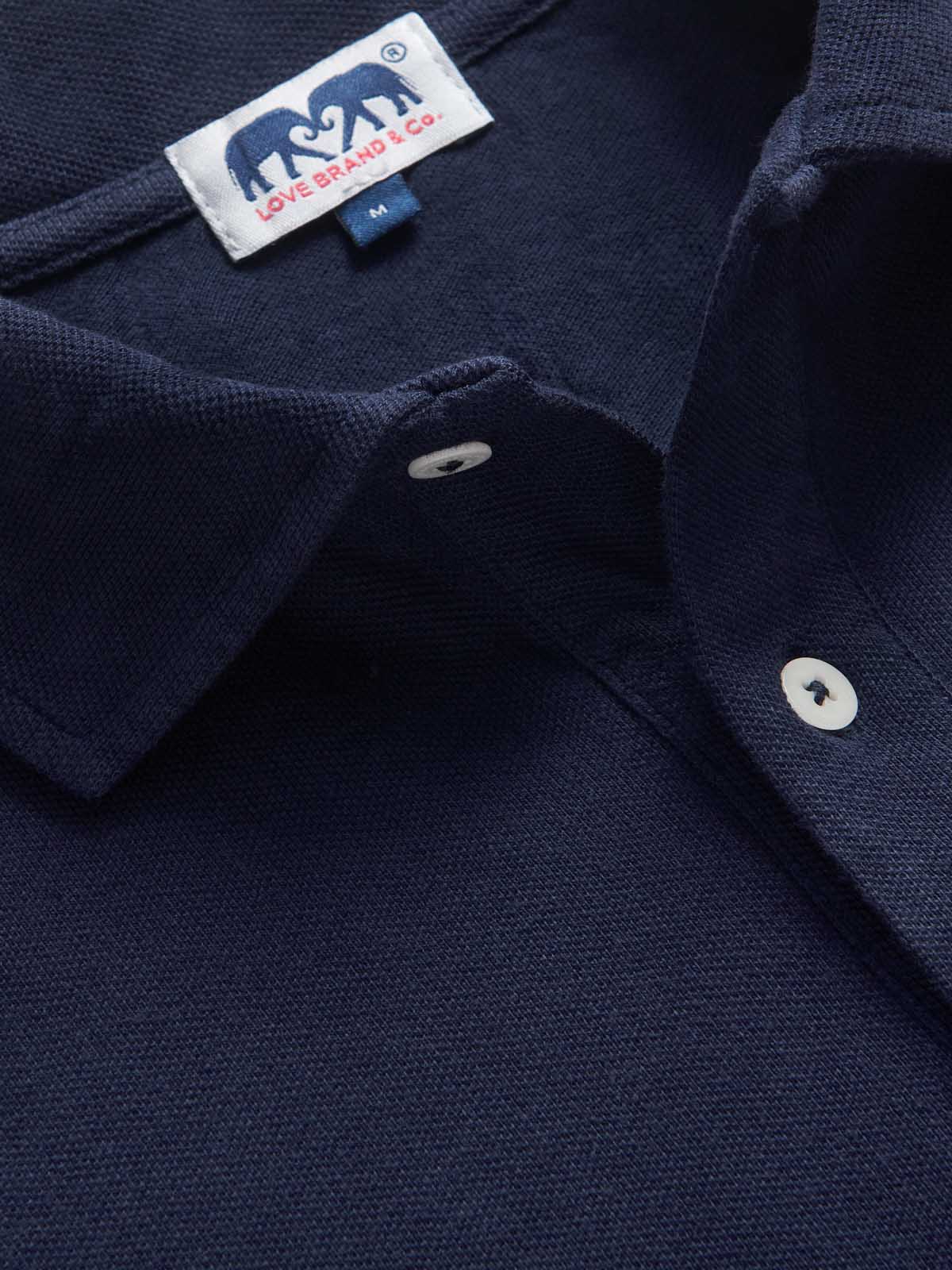 Close-up of men's navy blue polo shirt showing love brand label.
