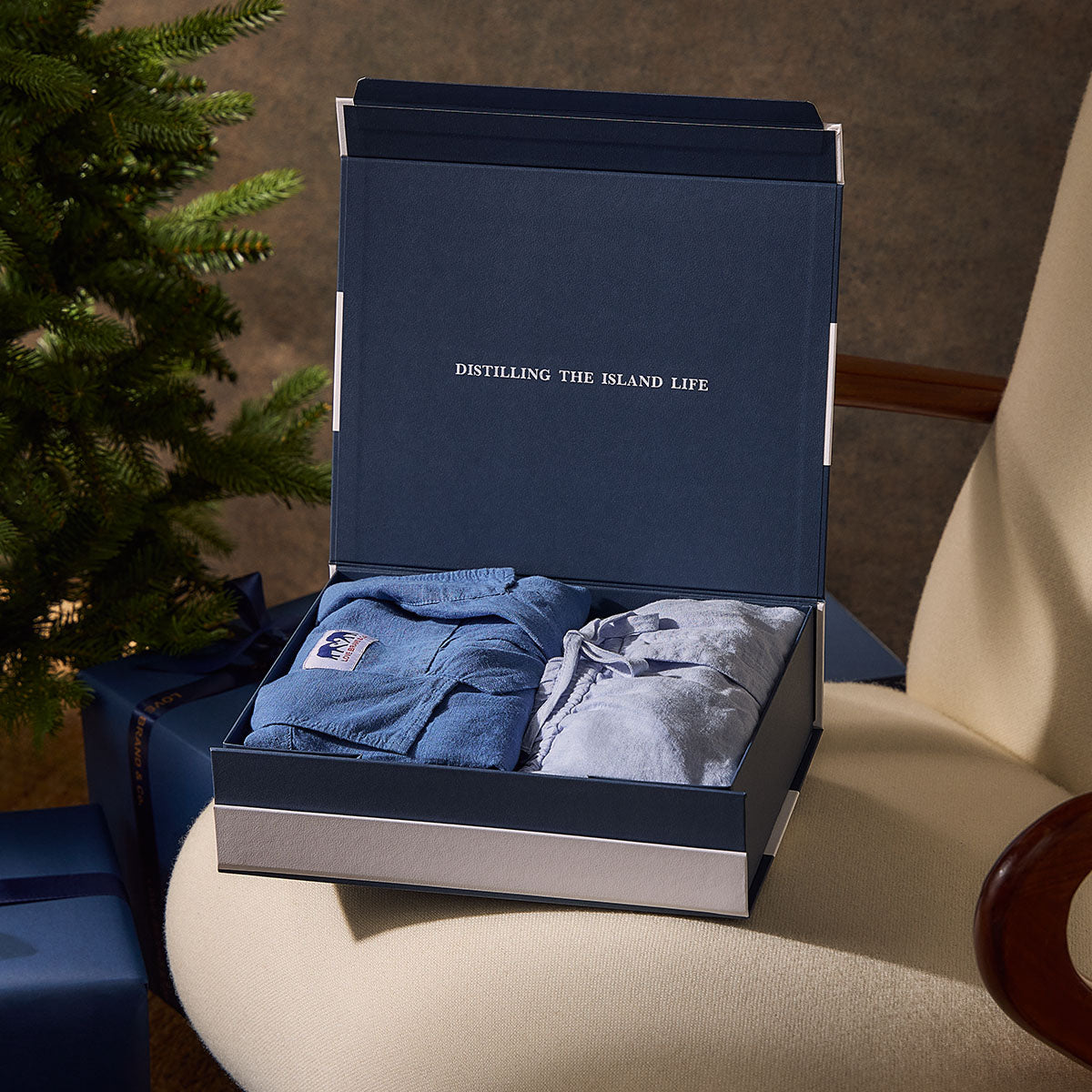 Open navy gift box with clothing inside.