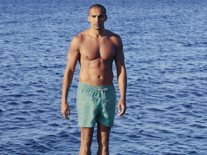 Model wearing Love Brand's mens sustainable swim shorts