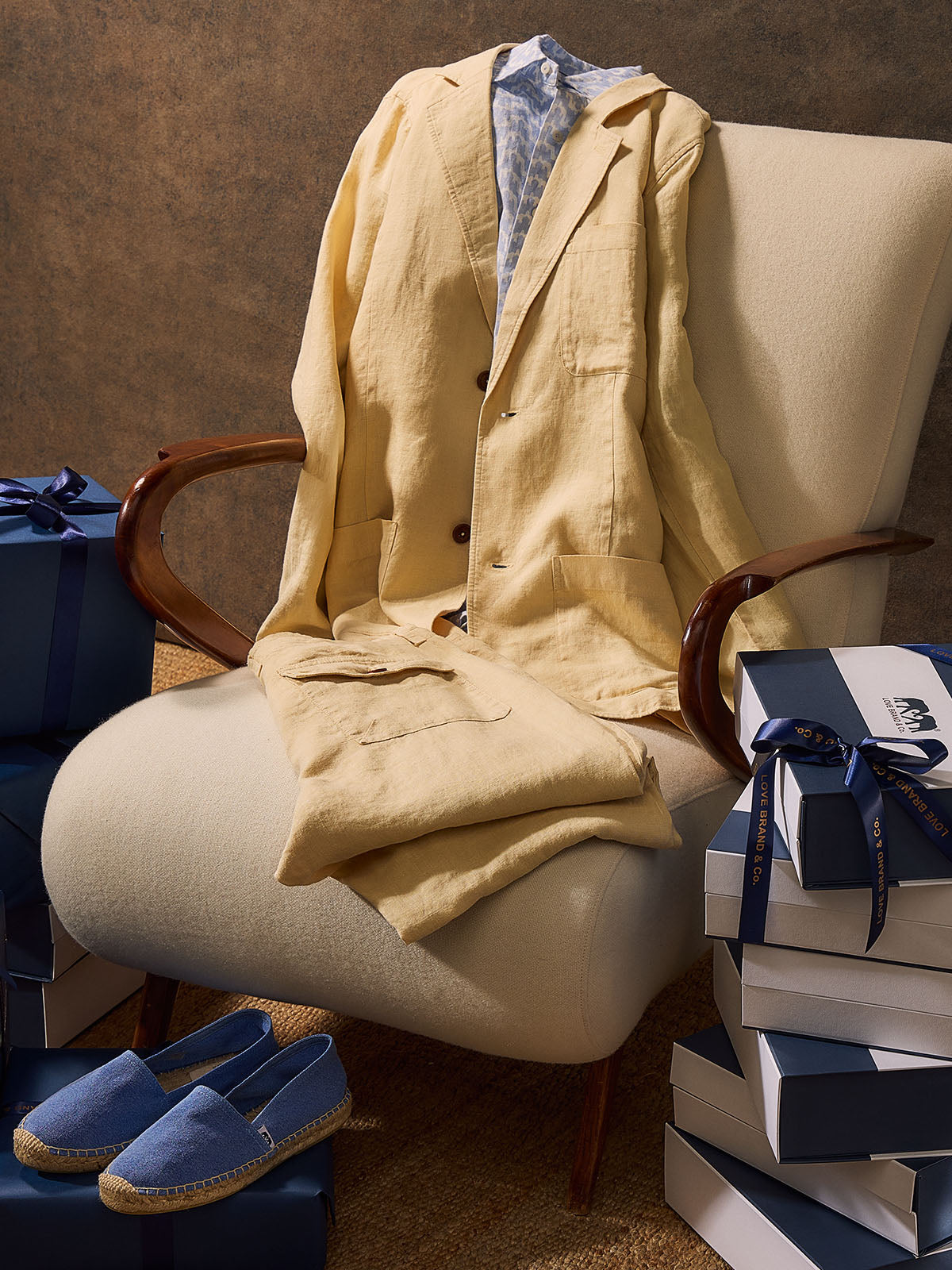 Beige jacket draped over a chair with blue shoes and wrapped gifts in the background