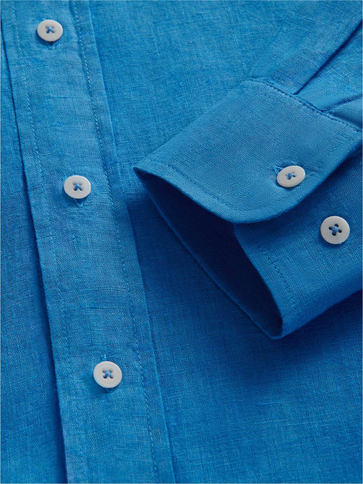 Close-up of a blue linen shirt with buttons and a collar.