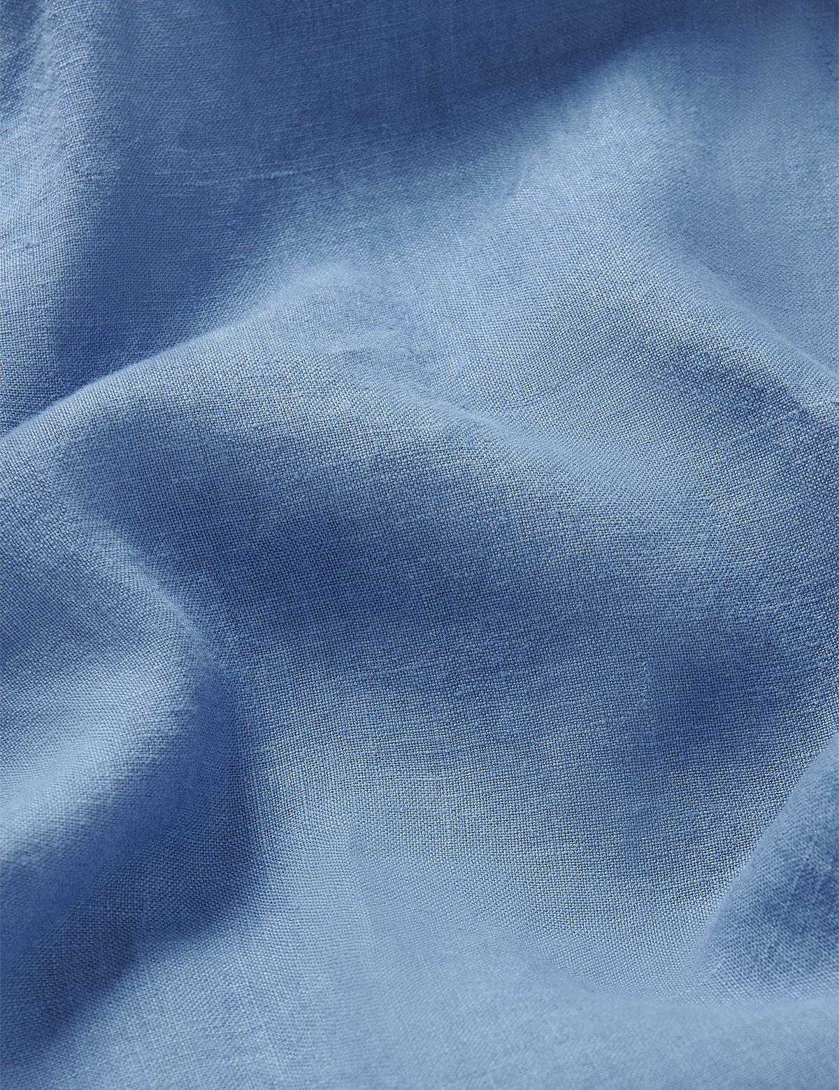 Close-up view of the luxurious blue linen fabric used in Men's Deep Blue Eleuthera Linen Trousers. Close-up of mens blue linen trousers showcasing its fine texture and quality.