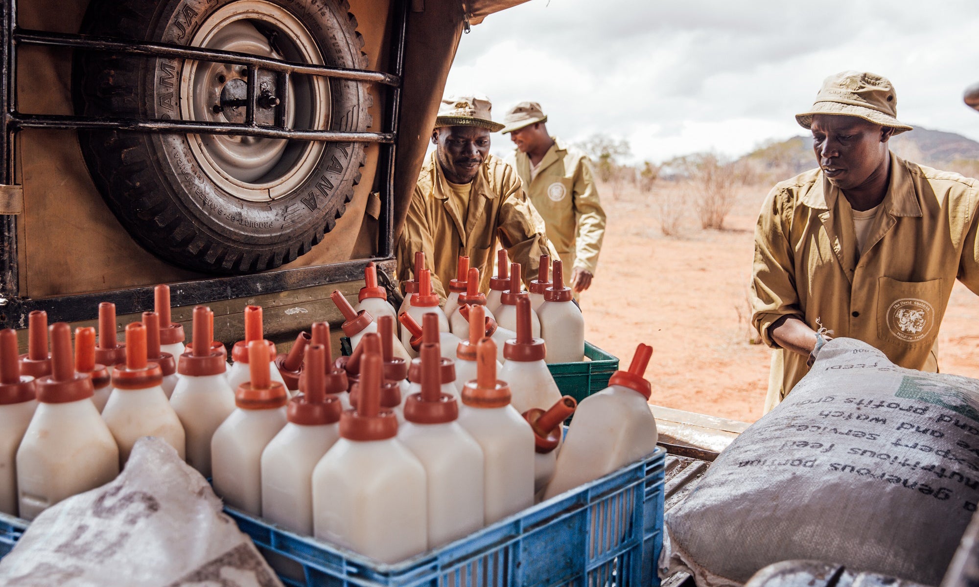Men loading milk bottles onto a truck in a rural setting