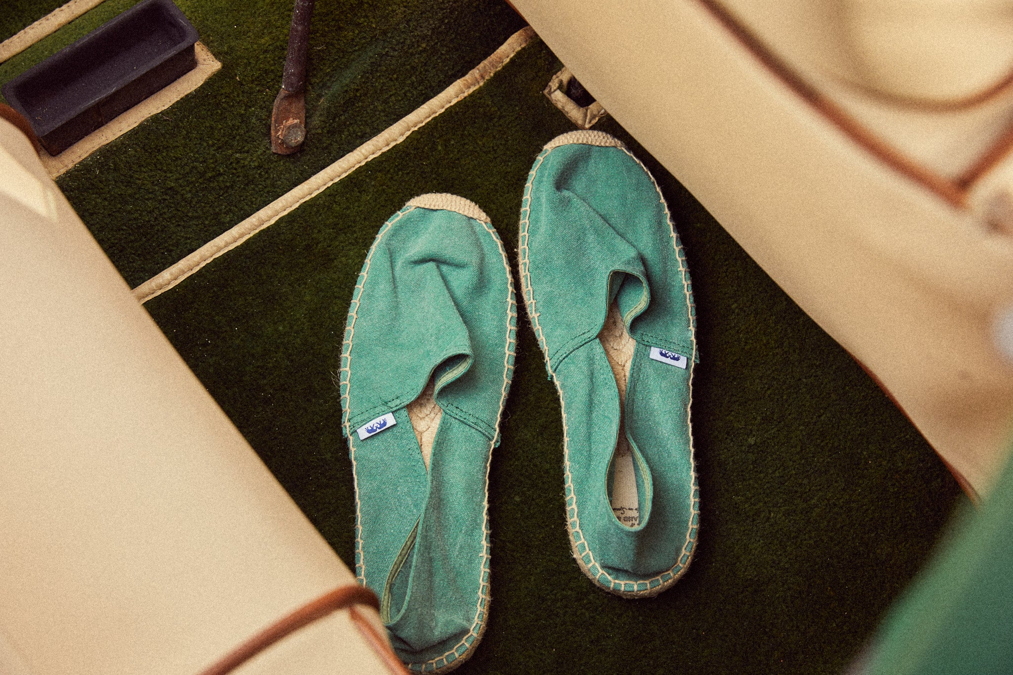 Green espadrille shows on a dark surface with a beige bag nearby for Mother's Day 2026
