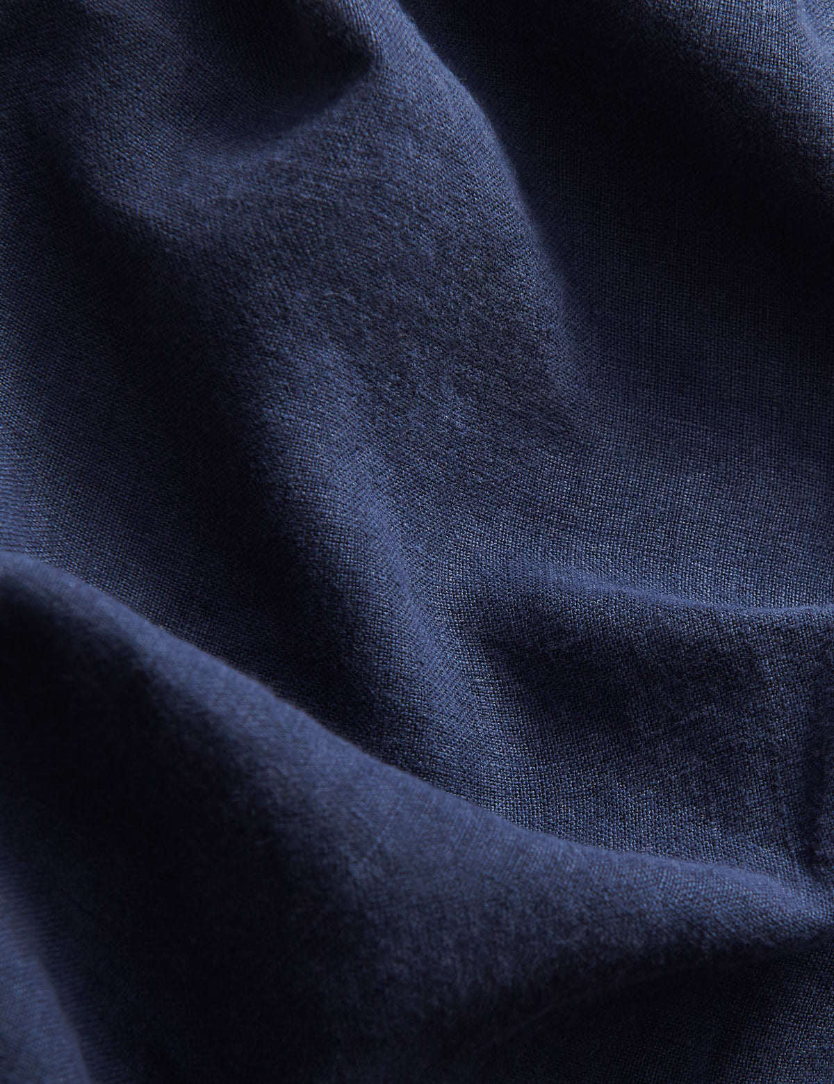 close-up view of navy blue linen fabric of love brand mens navy linen pants.