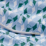 Close-up of the patterned fabric detail on the "Men's Which Way to the Tropics Staniel Swim Shorts," featuring an emerald and white manta ray design, with a white drawstring.