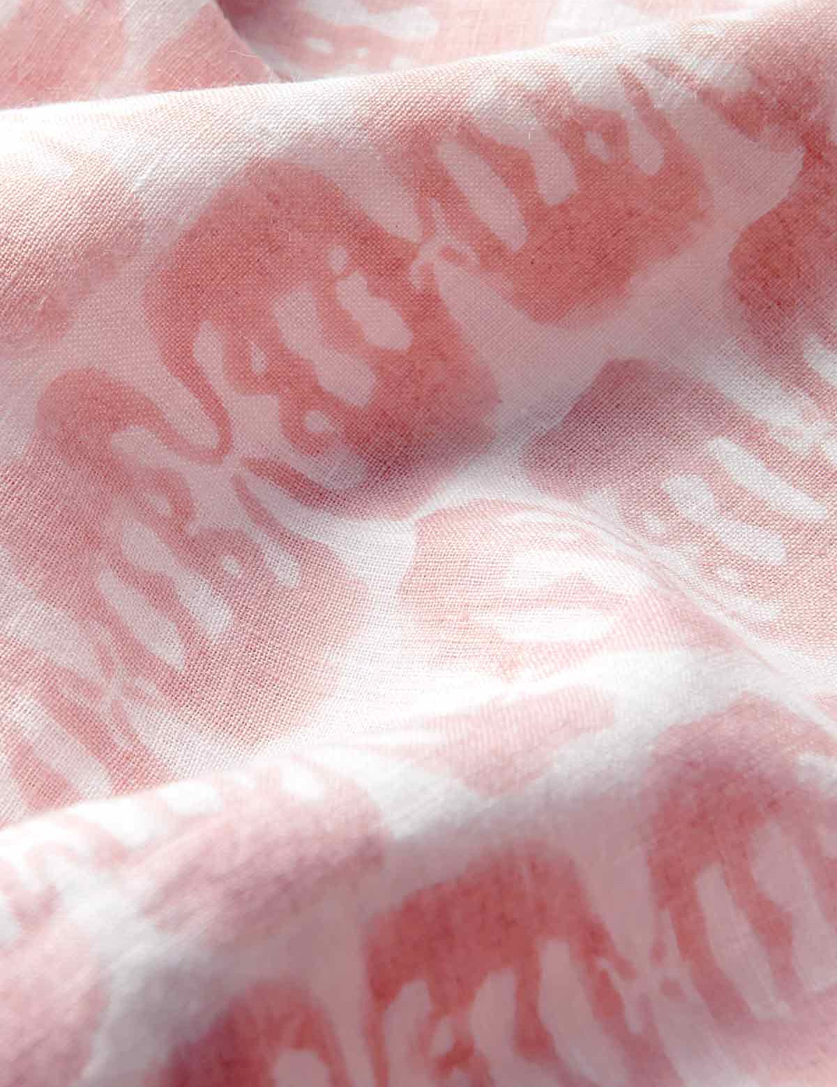 Close-up of pink linen trousers showing elephants of india print and premium linen fabric.